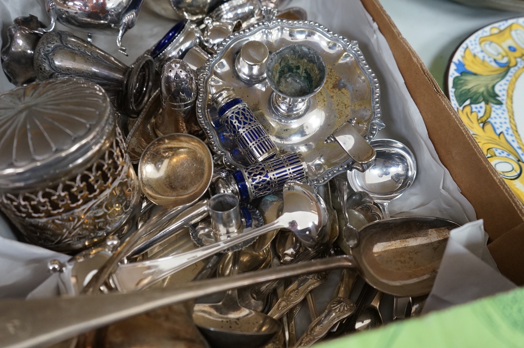 A collection of small plated wares including a pair of candle sticks, cruets, cutlery, sugar shaker, etc